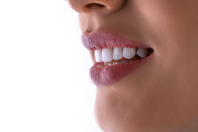 A person gently brushing and flossing around a dental implant with a soft-bristled toothbrush.